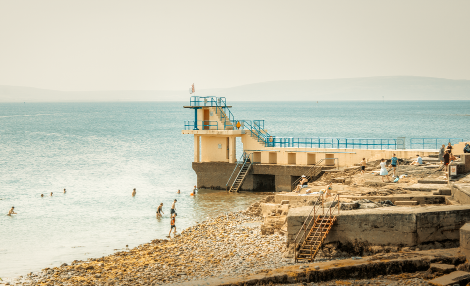 Sea swimmers at a seaside diving board on the Irish coast